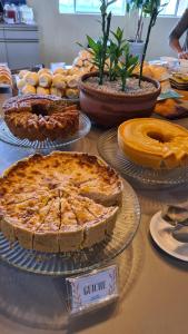 a table with pies and other foods on it at Arena Carneiros Hotel by AFT in Tamandaré