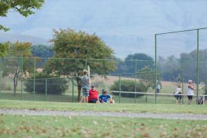 a group of people playing baseball in a field at Mountain Splendour Eco Resort in Winterton