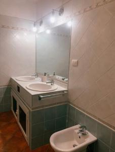 un bagno con due lavandini e un grande specchio di Moretti Mountain House - Relax in Nature a Gorreta