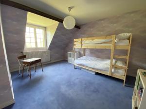 Un dormitorio con dos literas y una mesa. en Maison de campagne familiale sur la route des Châteaux, en Huisseau-sur-Mauves