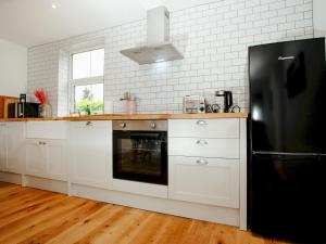 a kitchen with white cabinets and a black refrigerator at Pass the Keys Perfect for exploring the Wolds Lincoln in Market Rasen