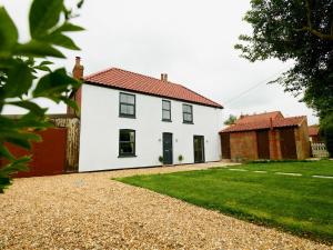 a white house with a red roof and a yard at Pass the Keys Perfect for exploring the Wolds Lincoln in Market Rasen