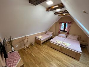 a attic room with two beds and a window at Penzion Arrow in Lesná