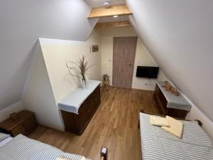 a attic room with two beds and a television at Penzion Arrow in Lesná