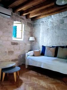 uma sala de estar com um sofá e uma mesa em Rooms Livia em Trogir