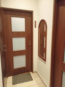 een bruine deur met een spiegel en een tegelvloer bij Kamienica przy Staszica in Lublin