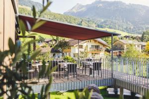 a restaurant with tables and chairs and a mountain at Hotel Hubertus - Au Bregenzerwald in Au im Bregenzerwald