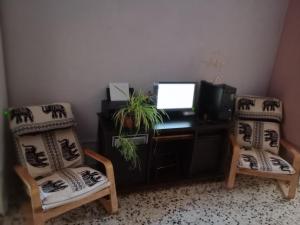 um escritório com duas cadeiras e uma secretária com um computador em Cerca de Sevilla Bosque Suspendido Ideal Familia em Bollullos de la Mitación