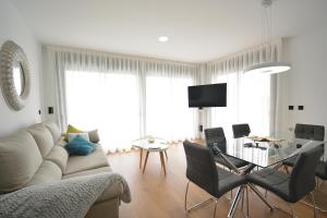 salon z kanapą i szklanym stołem w obiekcie GALIHOST - Apartamento con piscina en Canelas, Sanxenxo w mieście Sanxenxo