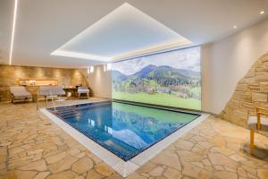 a swimming pool in a room with a large painting on the wall at Rübezahlbaude in Großschönau