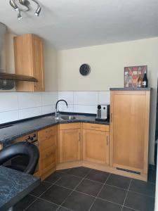 a kitchen with wooden cabinets and a sink at Bela‘s Ferienhaus in Komló