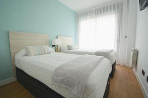 Łóżko lub łóżka w pokoju w obiekcie GALIHOST - Apartamento con piscina en Canelas, Sanxenxo