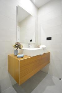 ein Bad mit einem Waschbecken und einem Spiegel in der Unterkunft Apartamento con piscina en Canelas, Sanxenxo in Sanxenxo