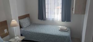 a small bedroom with a bed and a window at Happiness Apartment Center in Bitola