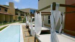a row of lounge chairs next to a swimming pool at Solar Águas Pipa Prime in Pipa