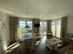 a living room with a table and a room with a view at Fehmarn-Ostseeferien"Strandleev3" 1423 App 3 in Fehmarnsund