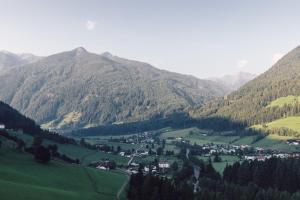 a town in the middle of a valley with mountains at Alpenpalace Luxury Hideaway & Spa Retreat in Lutago