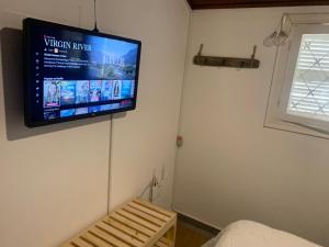 un televisor colgado en una pared en una habitación en Chalé da Araucária, en Campos do Jordão