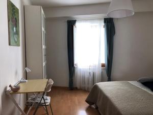 Schlafzimmer mit einem Bett, einem Schreibtisch und einem Fenster in der Unterkunft Ankon Apartment Palazzo Mazzini in Ancona