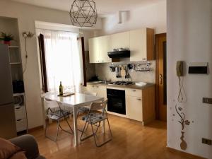 uma cozinha com mesa e cadeiras num quarto em Ankon Apartment Palazzo Mazzini em Ancona
