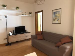 salon z kanapą i telewizorem w obiekcie Ankon Apartment Palazzo Mazzini w mieście Ancona