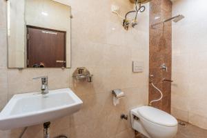 a bathroom with a sink and a toilet and a mirror at DIPLOMAT REGENCY in New Delhi