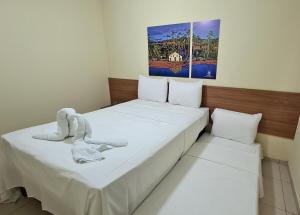 a bedroom with two beds with white sheets at Arena Carneiros Hotel by AFT in Tamandaré