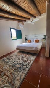 1 dormitorio con cama y alfombra en Casa Aventura, en Boliqueime