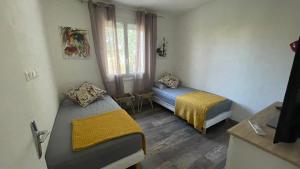 a room with two beds and a window at Jolie villa à UZES, climatisée avec piscine in Uzès