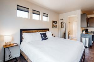 a bedroom with a large white bed and a kitchen at Hideaway in the Sun in Flagstaff