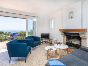 uma sala de estar com cadeiras azuis e uma lareira em Holiday Home Maragda by Interhome em Calonge
