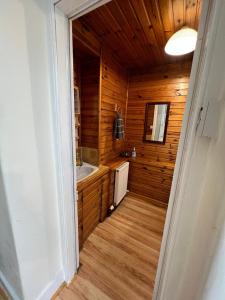a bathroom with wooden walls and a sink and a mirror at Ashley House in Inverness