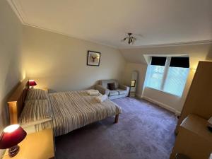 1 dormitorio con 2 camas y sofá en Ashley House en Inverness