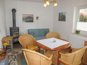 Holiday Home Enikö by Interhome في لوبمين: غرفة معيشة مع طاولة وكراسي وموقد
