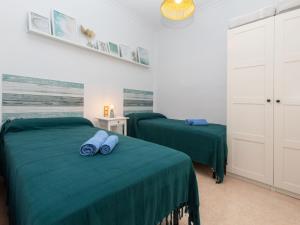 2 camas en una habitación con sábanas verdes en Apartment Portbou by Interhome, en Portbou