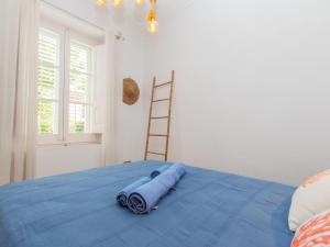 1 dormitorio con cama azul y escalera en Apartment Portbou by Interhome, en Portbou