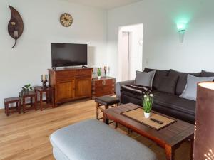 sala de estar con sofá y TV en Holiday Home Pusteblume by Interhome, en Hessenburg