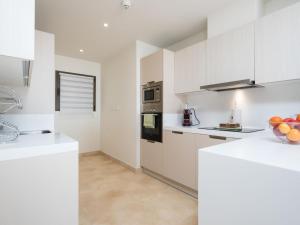 eine weiße Küche mit weißen Schränken und Geräten in der Unterkunft Apartment Cortesin Retreat by Interhome in Casares