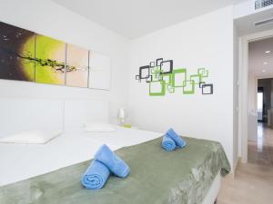 ein weißes Zimmer mit blauen Handtüchern auf einem Bett in der Unterkunft Apartment Cortesin Retreat by Interhome in Casares