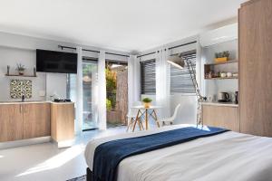 a bedroom with a large bed and a kitchen at Blouberg Studio Apartment in Bloubergstrand