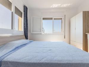 een slaapkamer met een groot bed en een blauwe deken bij Apartment Tabor-2 by Interhome in Torredembarra