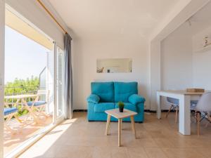 een woonkamer met een blauwe stoel en een tafel bij Apartment Tabor-2 by Interhome in Torredembarra