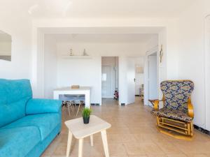 een woonkamer met een blauwe bank en een tafel bij Apartment Tabor-2 by Interhome in Torredembarra