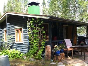 a log cabin with a table and a green chimney at Holiday Home Mirkunranta by Interhome in Salla