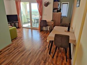 a living room with a table and chairs and a television at Apartments Lumar in Palit