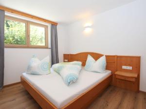 a bedroom with a bed with blue and white pillows at Apartment Bernadette by Interhome in Aschau