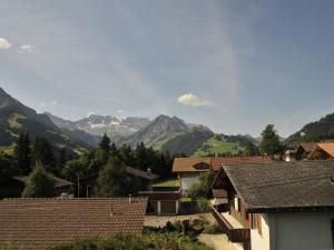 a village with mountains in the background with houses at Apartment Am Liimerweg by Interhome in Adelboden