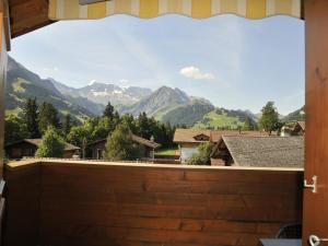 a view of mountains from a house window at Apartment Am Liimerweg by Interhome in Adelboden