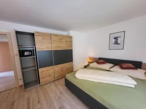 a small bedroom with a bed and a refrigerator at Apartment Frieda by Interhome in Zams