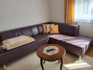 a brown leather couch in a living room with a table at Apartment Frieda by Interhome in Zams